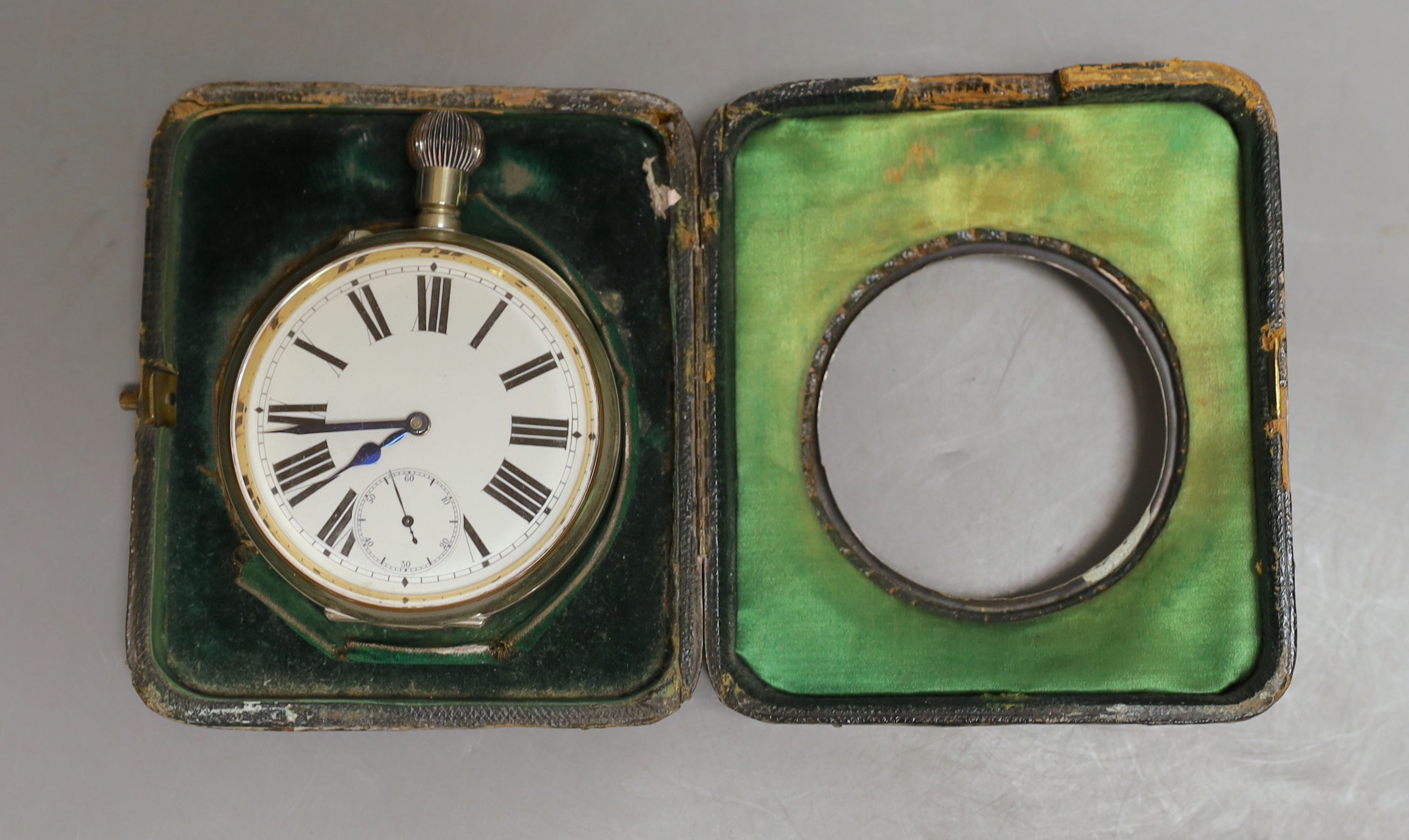 An early 20th century hammered silver mounted travelling watch case, marks rubbed, with keyless Goliath pocket watch.